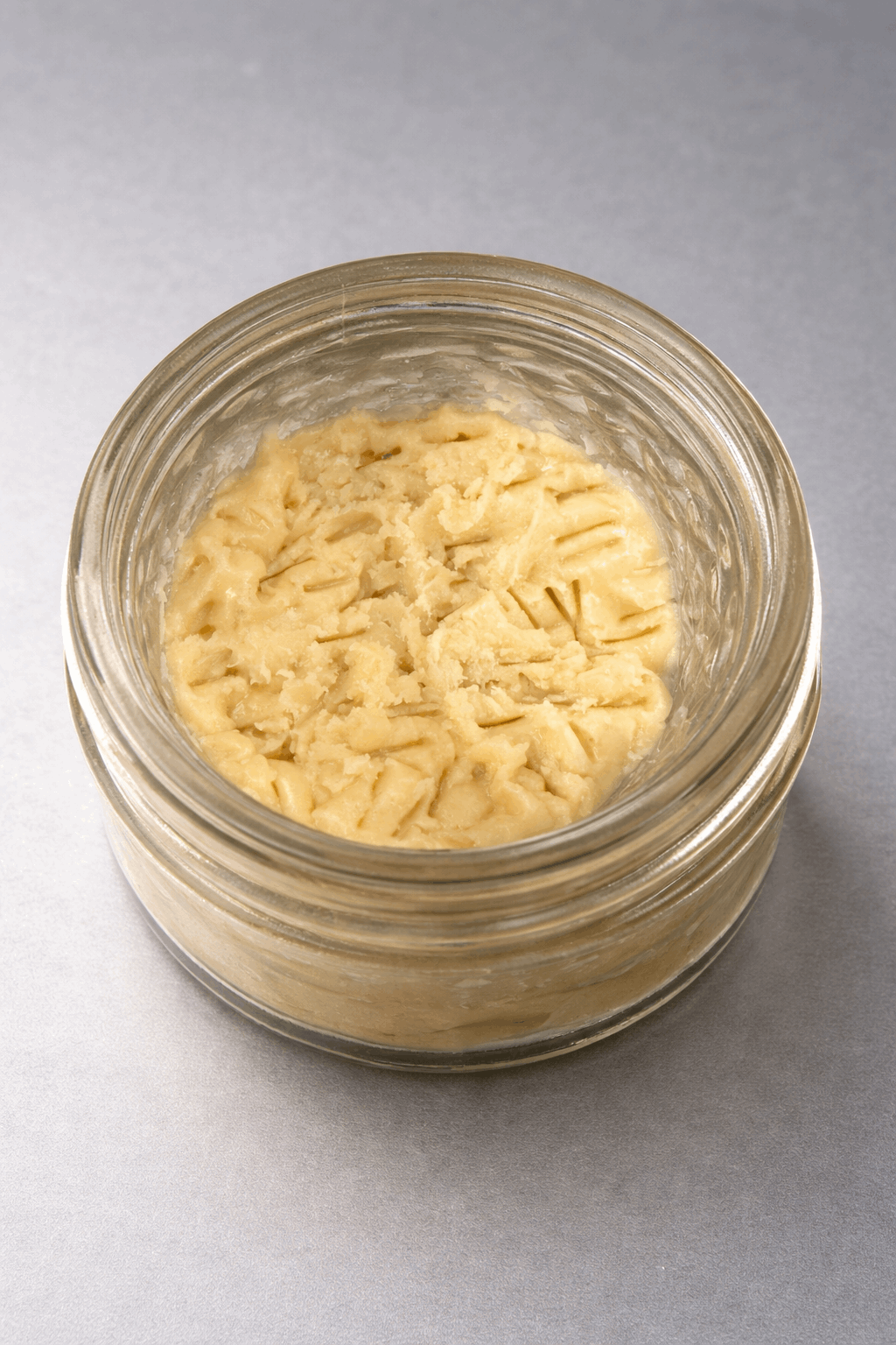 1 gram of I Am Hemp Inc live hash rosin concentrate with 78.6% potency, shown in a clear container with golden, sticky resin.